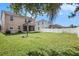 Wide shot of back exterior view of home featuring a large backyard with white fence at 7641 Armonk Ln, Wesley Chapel, FL 33545
