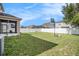 Expansive backyard featuring a white fence, lush grass, and a basketball hoop, perfect for outdoor activities at 7641 Armonk Ln, Wesley Chapel, FL 33545