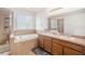 Bathroom featuring a double vanity, a large soaking tub and a separate walk-in shower at 7641 Armonk Ln, Wesley Chapel, FL 33545