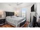Relaxing bedroom with a luxurious upholstered headboard and a view through the window at 7641 Armonk Ln, Wesley Chapel, FL 33545