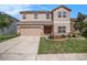 Charming two-story home boasts a well-manicured lawn, attached garage, and inviting curb appeal at 7641 Armonk Ln, Wesley Chapel, FL 33545