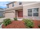 Inviting front entrance showcasing a red double door and stone accents and meticulously maintained landscaping at 7641 Armonk Ln, Wesley Chapel, FL 33545