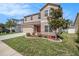 Two-story home featuring manicured lawn, landscape, and a neutral-colored stucco exterior at 7641 Armonk Ln, Wesley Chapel, FL 33545