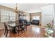 Open-concept living area with laminate floors, natural light, chandelier, and dining and living furniture at 7641 Armonk Ln, Wesley Chapel, FL 33545