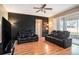 Cozy living room featuring sleek black leather sofas and bright, modern lighting at 7641 Armonk Ln, Wesley Chapel, FL 33545