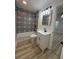 This bathroom has a patterned tile wall, black hardware, and wood-look floors at 7703 Glenview Ln, Tampa, FL 33615