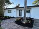 Charming single-story home featuring a newly landscaped yard with vibrant plants and brick paver walkway at 7703 Glenview Ln, Tampa, FL 33615