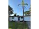 Single-story home with white exterior, black trim, landscaping and brick walkway, set against a blue sky at 7703 Glenview Ln, Tampa, FL 33615