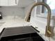 Kitchen detail featuring a stainless steel sink and marble countertops, and modern gold faucet at 7703 Glenview Ln, Tampa, FL 33615