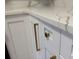 Close-up of the kitchen's white cabinets with modern gold hardware and sleek marble countertops at 7703 Glenview Ln, Tampa, FL 33615