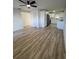 Open-concept home featuring a modern kitchen with white cabinets, stainless steel appliances, and light wood floors at 7703 Glenview Ln, Tampa, FL 33615