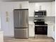 Modern kitchen featuring stainless steel appliances, sleek white cabinets, and beautiful countertops at 7703 Glenview Ln, Tampa, FL 33615