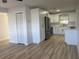 Open-concept home showcasing a modern kitchen with white cabinets, stainless steel appliances and light wood floors at 7703 Glenview Ln, Tampa, FL 33615