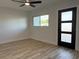 Modern living room featuring light wood floors, white walls, new windows, and a stylish three-panel front door at 7703 Glenview Ln, Tampa, FL 33615