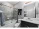 Modern bathroom featuring a tiled shower, a toilet, dark storage cabinets and a large mirror at 8019 Marbella Creek Ave, Tampa, FL 33625