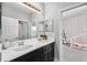 Bright bathroom with double vanity, granite countertop, large mirror and view into the bedroom at 8019 Marbella Creek Ave, Tampa, FL 33625