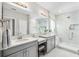 Bright bathroom featuring double sinks, granite countertops, and walk-in shower with white marble-look tile at 8019 Marbella Creek Ave, Tampa, FL 33625
