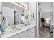 Bathroom with double sinks, a granite countertop, framed mirrors and views to the adjacent bedroom and shower at 8019 Marbella Creek Ave, Tampa, FL 33625