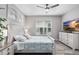 Bright bedroom with a ceiling fan, whitewashed wood furnishings and a mounted television at 8019 Marbella Creek Ave, Tampa, FL 33625