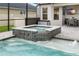 Inviting pool with jacuzzi and beautiful tile work, adjacent to covered patio and outdoor dining at 8019 Marbella Creek Ave, Tampa, FL 33625