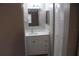 Clean bathroom with white vanity, a well-lit mirror, and convenient storage at 8234 Ravencroft Dr, Tampa, FL 33615