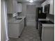 Modern kitchen with white cabinets, stainless steel appliances, and a view to the dining area at 8234 Ravencroft Dr, Tampa, FL 33615