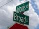 A green street sign for Adonis Road and Broad Street at 8617 Broad St, New Port Richey, FL 34654