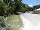 Asphalt street surrounded by lush green trees and various parked vehicles at 8617 Broad St, New Port Richey, FL 34654