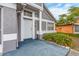Welcoming front entrance with a light gray finish, white door, and a small garden bed at 921 Linn Harbor Ct, Tarpon Springs, FL 34689