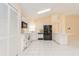 Bright kitchen with white cabinetry, tile floor, and black appliances at 921 Linn Harbor Ct, Tarpon Springs, FL 34689