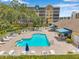 Community pool area with lounge chairs, umbrellas, and lush landscaping at condominium complex at 960 Starkey Rd # 7503, Largo, FL 33771