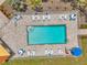 Aerial view of community pool with lounge chairs, umbrellas, and tables for relaxation at 960 Starkey Rd # 7503, Largo, FL 33771