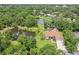 Beautiful aerial view of a home with pond frontage, lush trees, well-maintained lawns and outdoor pool at 10113 Bell Creek Dr, Riverview, FL 33569