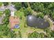 Aerial view of a home with a pool, backyard, and pond highlighting a secluded property with surrounding greenery at 10113 Bell Creek Dr, Riverview, FL 33569