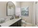 Well-lit bathroom with a sleek black faucet and a large, arched mirror above the vanity at 10113 Bell Creek Dr, Riverview, FL 33569
