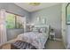 Inviting bedroom features a cozy bed, coastal-themed decor, and window views of lush greenery for a peaceful retreat at 10113 Bell Creek Dr, Riverview, FL 33569