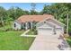 Aerial view of a one-story home with a large, well-maintained lawn, three-car garage, and landscaping at 10113 Bell Creek Dr, Riverview, FL 33569