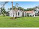 View of a one-story home with a well-manicured lawn and landscaping, and a screened in lanai in the back at 10113 Bell Creek Dr, Riverview, FL 33569