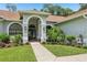 Inviting front entrance with a blue double door, beautiful landscaping, and a tiled walkway leading to the home at 10113 Bell Creek Dr, Riverview, FL 33569