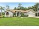 Well-maintained one-story home featuring a well-manicured lawn, an arched entryway, and a three-car garage with a gray exterior at 10113 Bell Creek Dr, Riverview, FL 33569