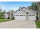 Attached three-car garage with white doors and decorative windows, showcasing ample parking and curb appeal at 10113 Bell Creek Dr, Riverview, FL 33569