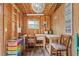 Bright shed interior featuring wood walls, chandelier, desk and crafting area at 10113 Bell Creek Dr, Riverview, FL 33569