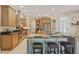 Spacious kitchen with stainless steel appliances, a granite island with seating, and warm wood cabinetry at 10113 Bell Creek Dr, Riverview, FL 33569