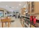 Open-concept kitchen with black countertops, an island, custom cabinets, and stainless steel appliances at 10113 Bell Creek Dr, Riverview, FL 33569