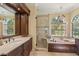 A naturally lit main bathroom featuring dual vanities, soaking tub, and walk in shower at 10113 Bell Creek Dr, Riverview, FL 33569