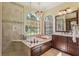 A naturally lit main bathroom featuring dual vanities, soaking tub, and walk in shower at 10113 Bell Creek Dr, Riverview, FL 33569