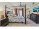 Spacious main bedroom featuring a four-poster bed, ceiling fan, and backyard views at 10113 Bell Creek Dr, Riverview, FL 33569