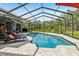 Outdoor pool with lounge chairs and screened enclosure offering scenic backyard views at 10113 Bell Creek Dr, Riverview, FL 33569