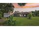 Home featuring a screened-in pool, backyard, mature landscaping, and exterior shed at 10113 Bell Creek Dr, Riverview, FL 33569