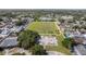 A high aerial view of a large, maintained athletic field and basketball court with a pond in the distance at 10202 Bellhurst Ct, Tampa, FL 33615